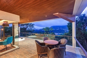 A modern outdoor seating area with a view of a mountainous landscape. - Aamby Valley City, Lonavala (Paud)