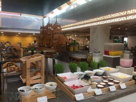 A buffet area with various food items and a ship-shaped decoration.