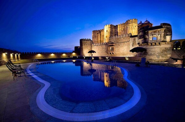 A historic castle with a large reflective pool in the foreground. - Fort Khejarla (Bilara)