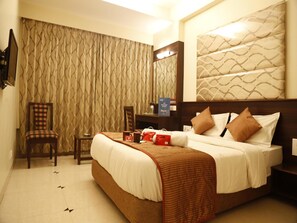 A hotel room with a bed, a chair, a desk, and a television. - OYO Rooms Old Pune Bangalore Road Kolhapur (Kolhapur)
