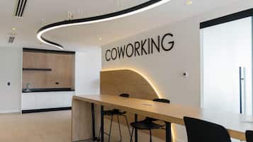 Un espace de travail partagé moderne, doté d’une grande table, de chaises noires et d’un panneau indiquant « ESPACE DE COWORKING ».