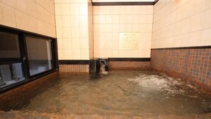 A wet floor in a tiled room with a trash bin and a window. - Green Rich Hotel Hiroshima (Hiroshima)