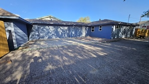 A residential area with a paved driveway, a garage, and a blue house. - Comfy 3BD Dog Friendly home! (Colorado Springs)