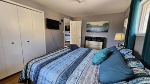 A bedroom with a bed, a dresser, a television, and a painting on the wall. - Comfy 3BD Dog Friendly home! (Colorado Springs)
