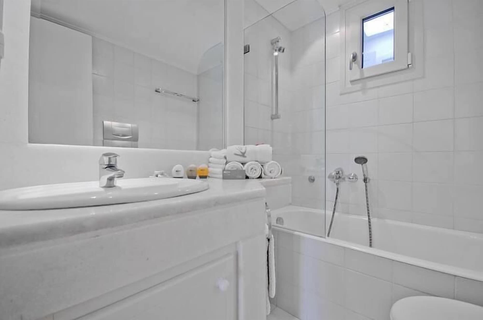 Un bagno moderno con lavabo, specchio, porta asciugamani e doccia.