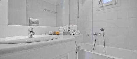 Un bagno moderno con lavabo, specchio, porta asciugamani e doccia.