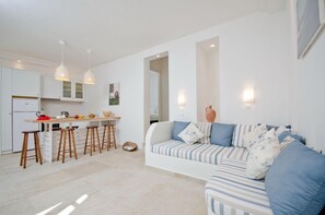 A modern kitchen with bar stools, a dining table, and pendant lights. - Kavos Boutique Hotel Naxos (Naxos)