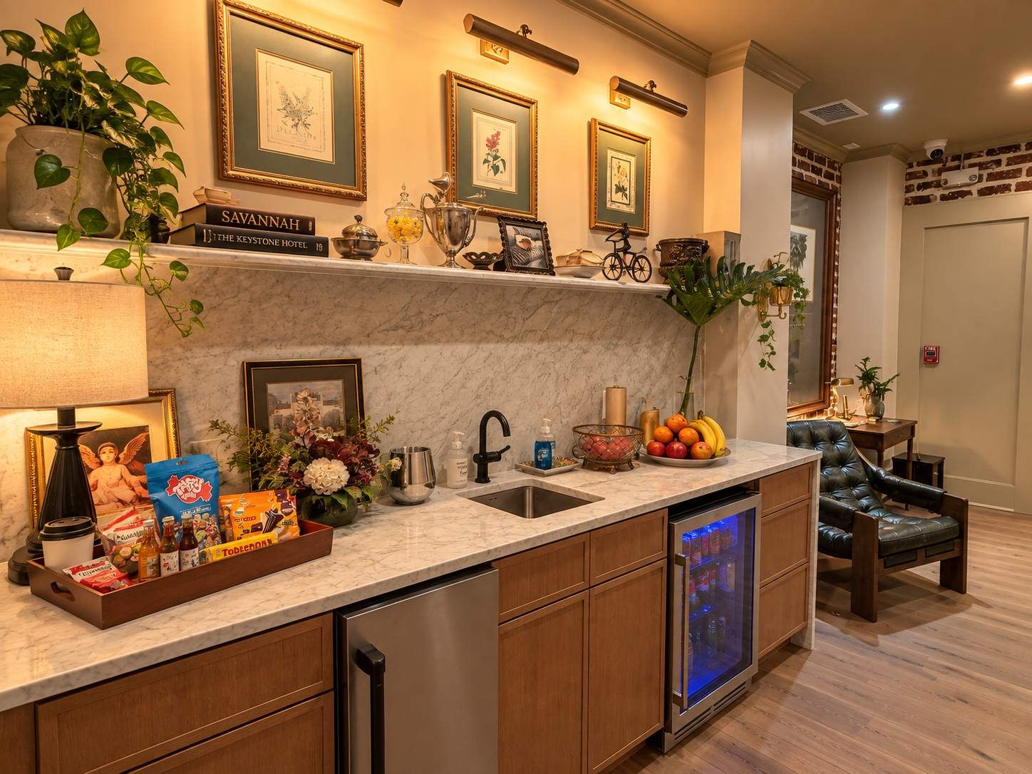 Una cocina moderna con encimeras de mármol, lavavajillas integrado y un refrigerador con puerta de vidrio.