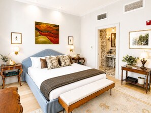 A bedroom with a bed, bedside tables, a bench, and artwork on the walls. - Aunt Rachel's Room at Keystone - 203 (Savannah)