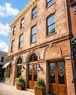 A brick building with arched windows and doors, labeled as 'The Keystone Hotel.' - Neiman's Room at Keystone Hotel - 202 (Savannah)