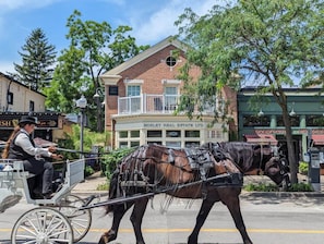 A horse-drawn carriage on a street with buildings in the background. - The Diana Suite - Elegant and Serene (Niagara-on-the-Lake)