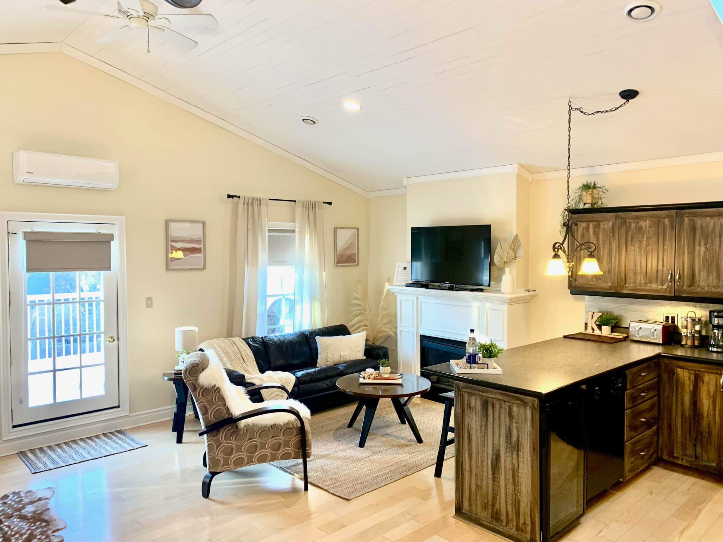A living room with a sofa, a coffee table, and a TV on a mantel.
