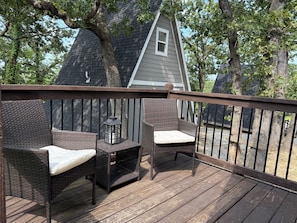 A wooden deck with wicker furniture and a lantern. - Table Rock Lake A-Frame Cabin | Black Oak Lodge 2 (Lampe)