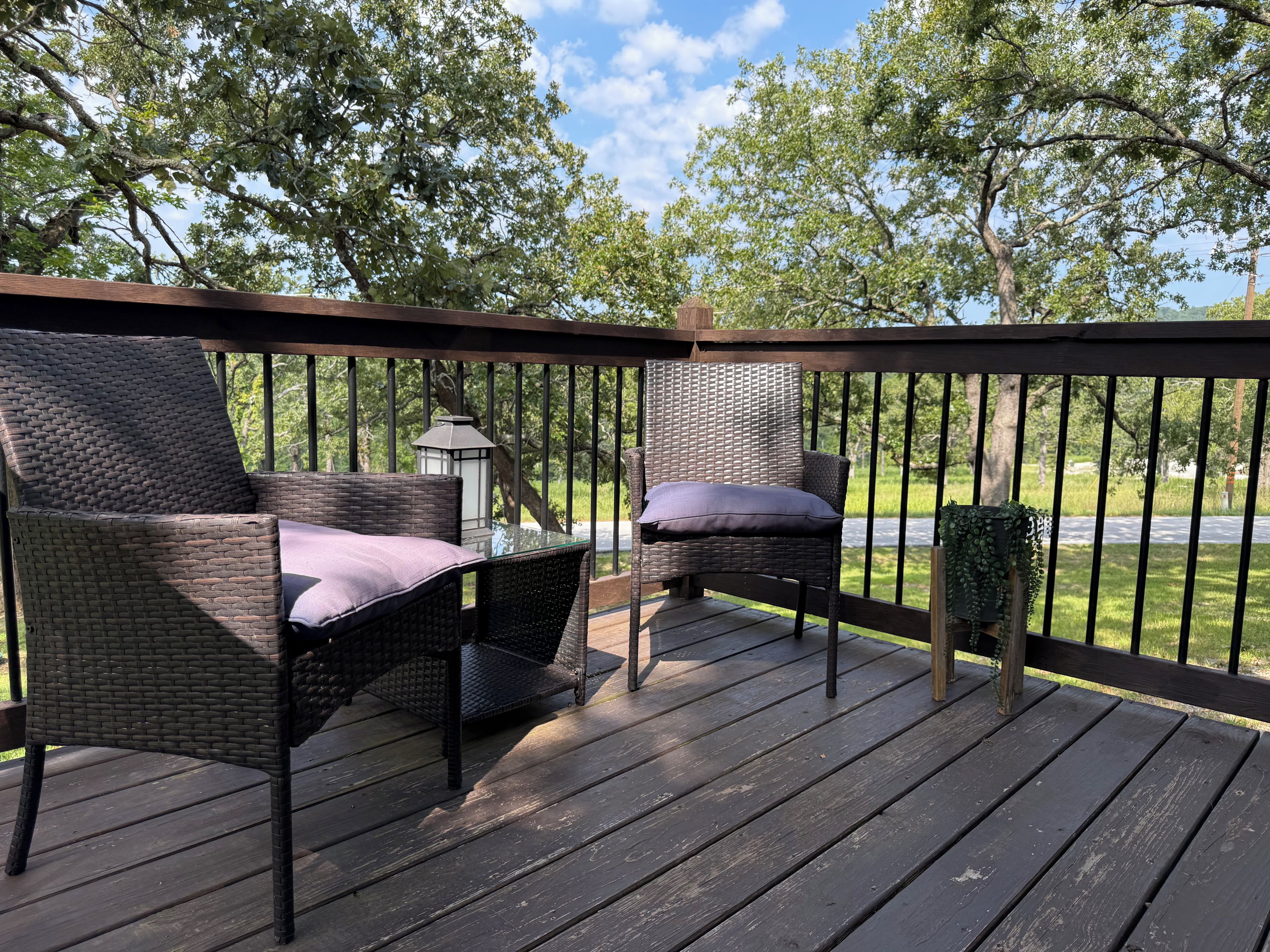 A deck with wicker furniture and a lantern.