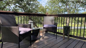 A deck with wicker furniture and a lantern.