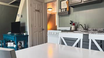 A compact kitchen with a stove, sink, and a dining area.