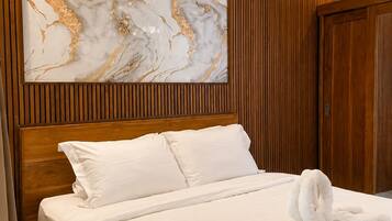 A hotel room with a wooden headboard, a marble artwork, and a neatly made bed.