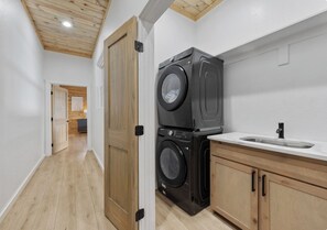 A laundry room with two stacked washers and a sink. - Lux•Insane Views•Sleep 26•Heated Pool•Game Room (Broken Bow)