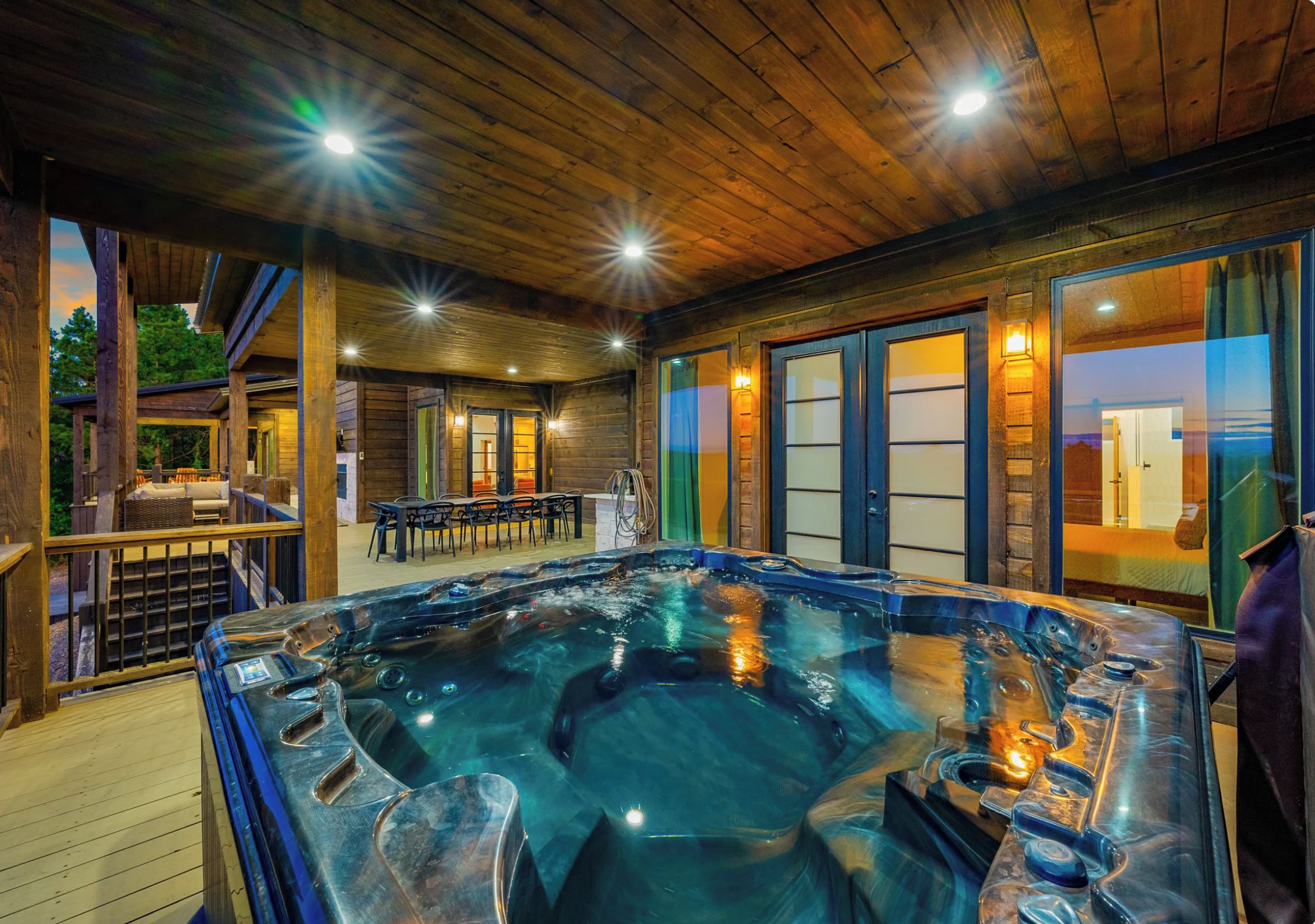 A hot tub area with wooden flooring and a view of the outdoors.