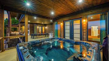 A hot tub area with wooden flooring and a view of the outdoors.