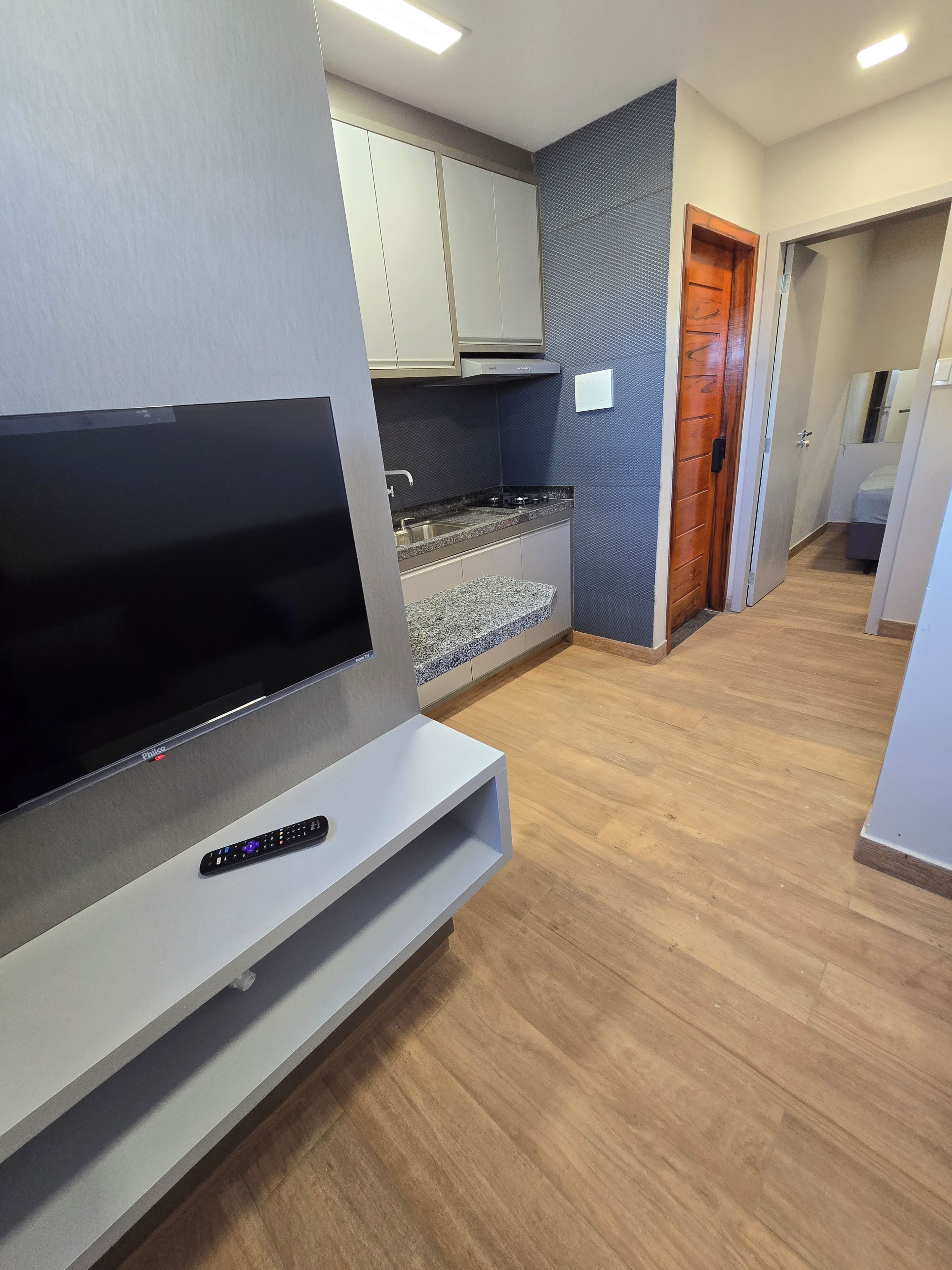Una cocina moderna con televisor integrado, estufa y alacenas.