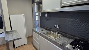 A modern kitchen with a stainless steel sink, a built-in microwave, and a gas stove.