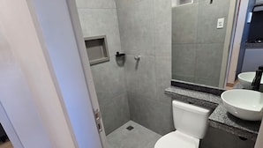 A modern bathroom with a shower, toilet, and sink.