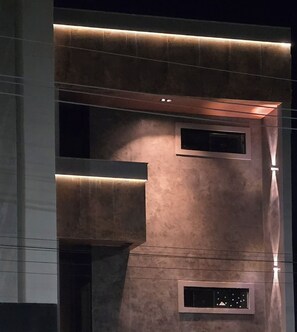 A building facade with recessed lighting and a series of rectangular windows.