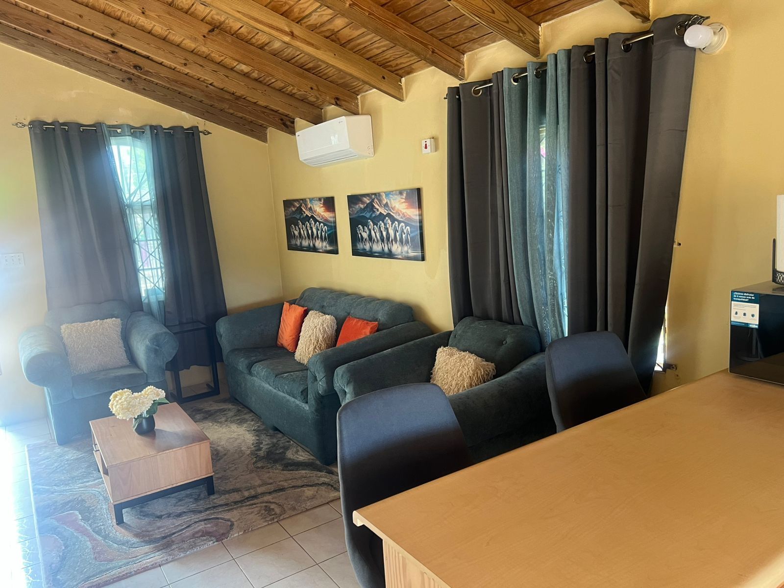 A living room with a sofa, chairs, a coffee table, and a TV.