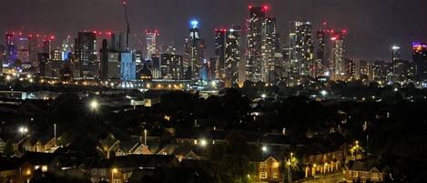 Un paisaje urbano nocturno con un perfil iluminado de edificios destacados.