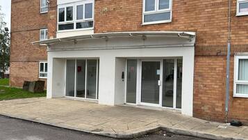 A multi-story building with a ground-level entrance featuring a glass door and a small awning.