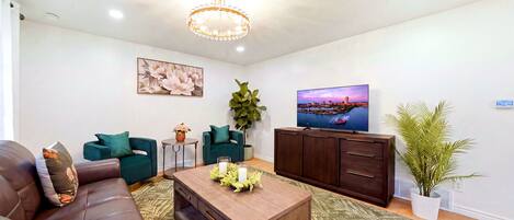 Una sala de estar moderna con un sofá, una mesa de centro, un televisor y una planta en maceta.