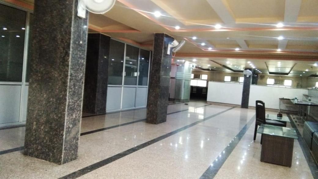 A spacious lobby with marble columns, a glass coffee table, and a reception desk.