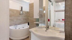 A modern bathroom with a freestanding bathtub, a large sink, and a mirror. - SMyleINN Farm Resort OPC (San Fernando)