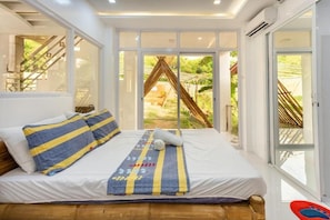 A bedroom with a bed, a window, and a view of the outdoors.