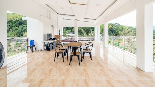 A spacious room with a wooden table and chairs, a computer, and a view of greenery. - SMyleINN Farm Resort OPC (San Fernando)