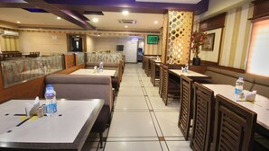 A restaurant with booths and tables, a cash register, and a menu board. - OYO Rooms Marathahalli Junction (Bengaluru)