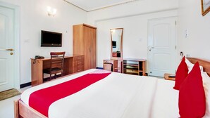 A hotel room with a bed, a desk, a chair, a wardrobe, a television, and a mirror. - OYO Rooms Marathahalli Junction (Bengaluru)