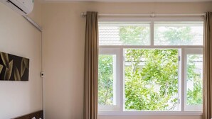 A hotel room with a bed, a desk, and a window with curtains. - Villa Panda (Phu Thuy)