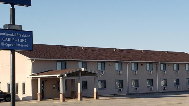 Un motel con un letrero que dice Burlington Stay Inn y servicios que incluyen desayuno continental, televisión por cable, HBO e internet de alta velocidad.