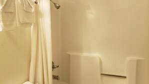 Un baño con bañera, cortina de ducha y barra para toallas.