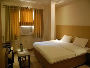 Ein Hotelzimmer mit einem Bett, einem Nachttisch und einem Schreibtisch mit Stuhl.
