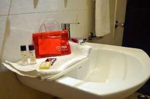 Ein Waschbecken mit Toilette und einer roten Tasche auf einem Handtuch.