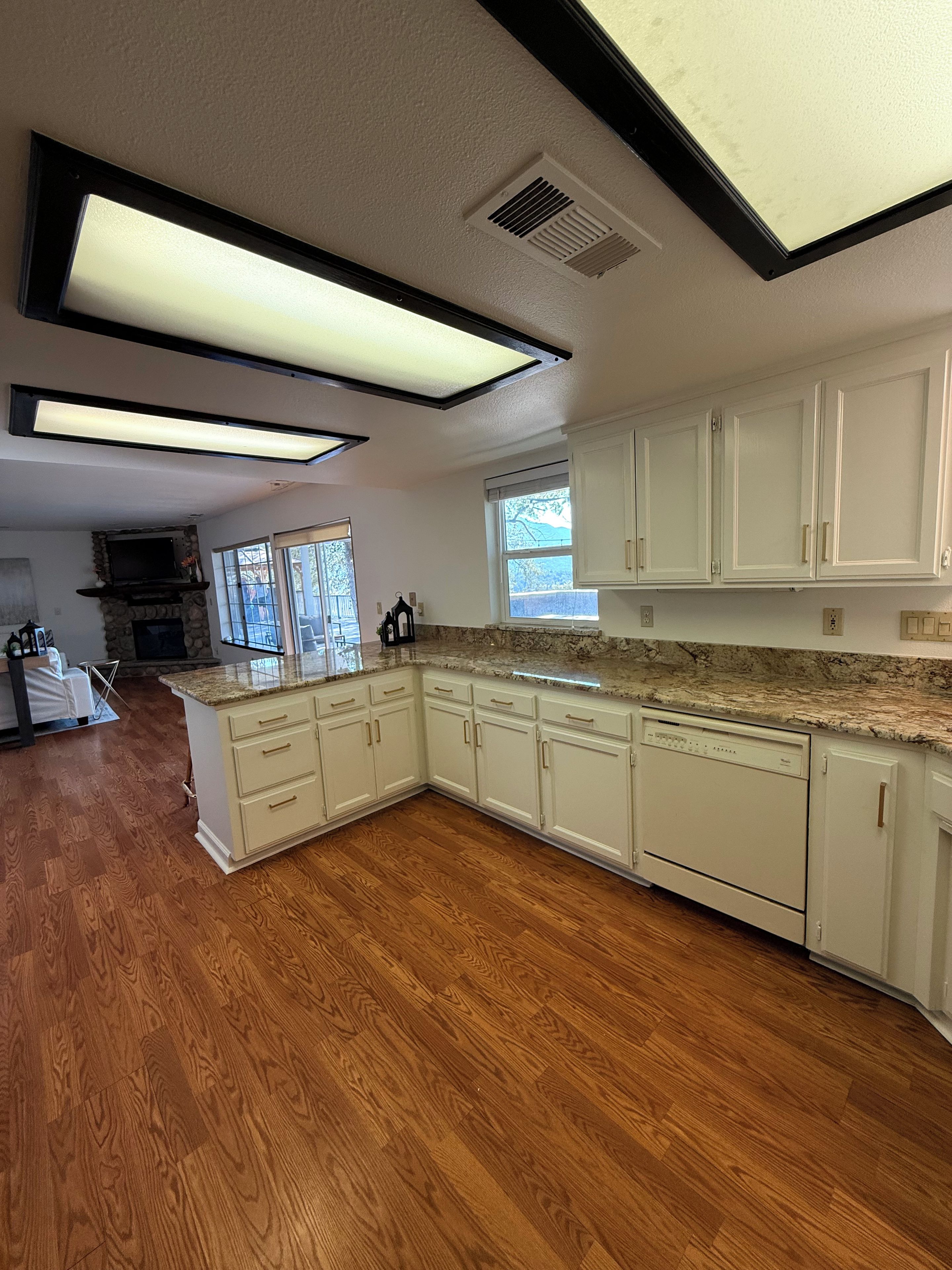 A kitchen with white cabinets, a granite countertop, and a built-in oven.