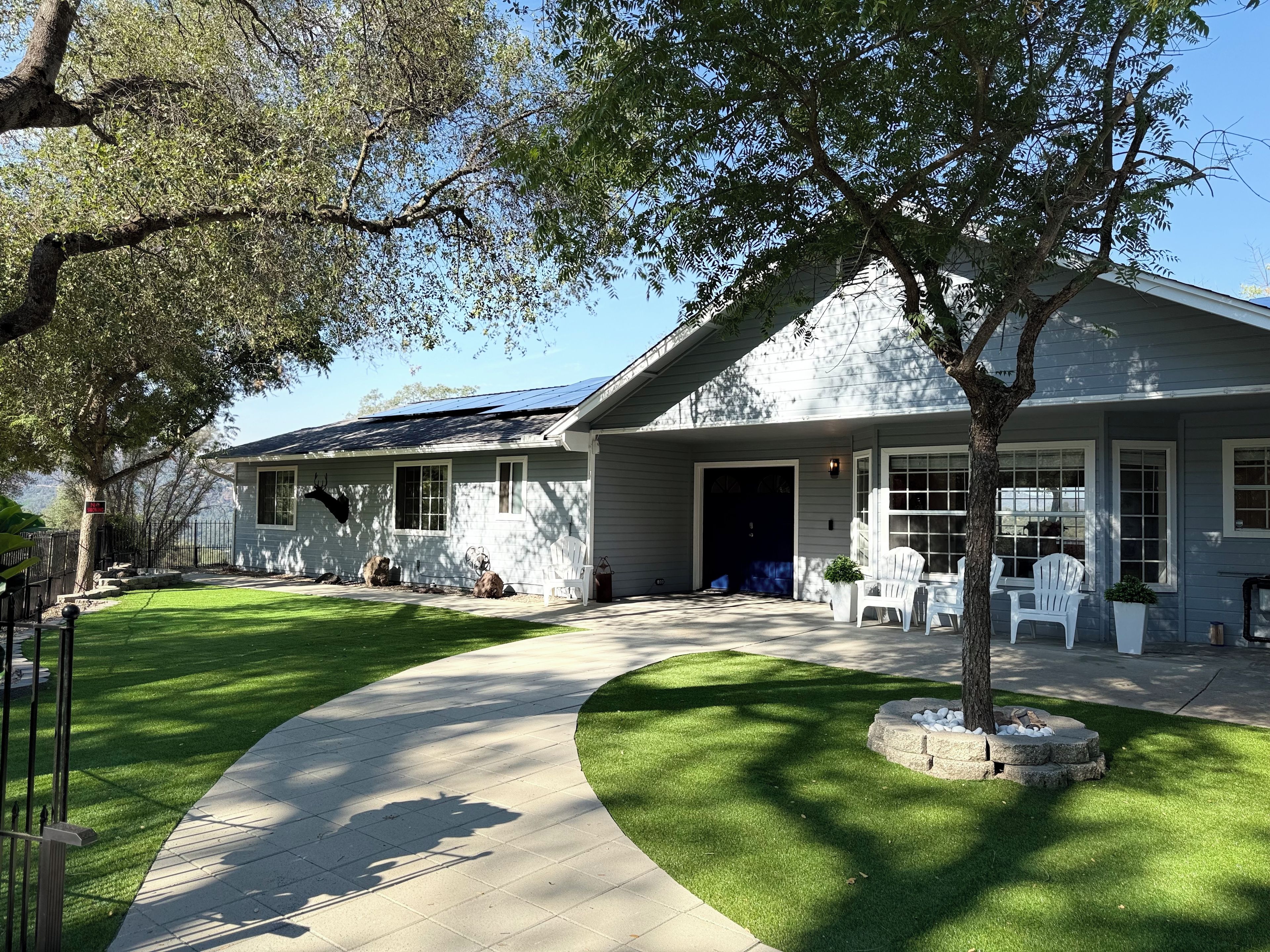 A residential property with a paved driveway, a lawn, and a house with a garage.
