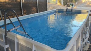 An above-ground swimming pool with a ladder and safety rail. - Relaxing Yosemite house w. Gorgeous Views, Hot tub, Sauna, Pool, Games, Gym, EV (Oakhurst)