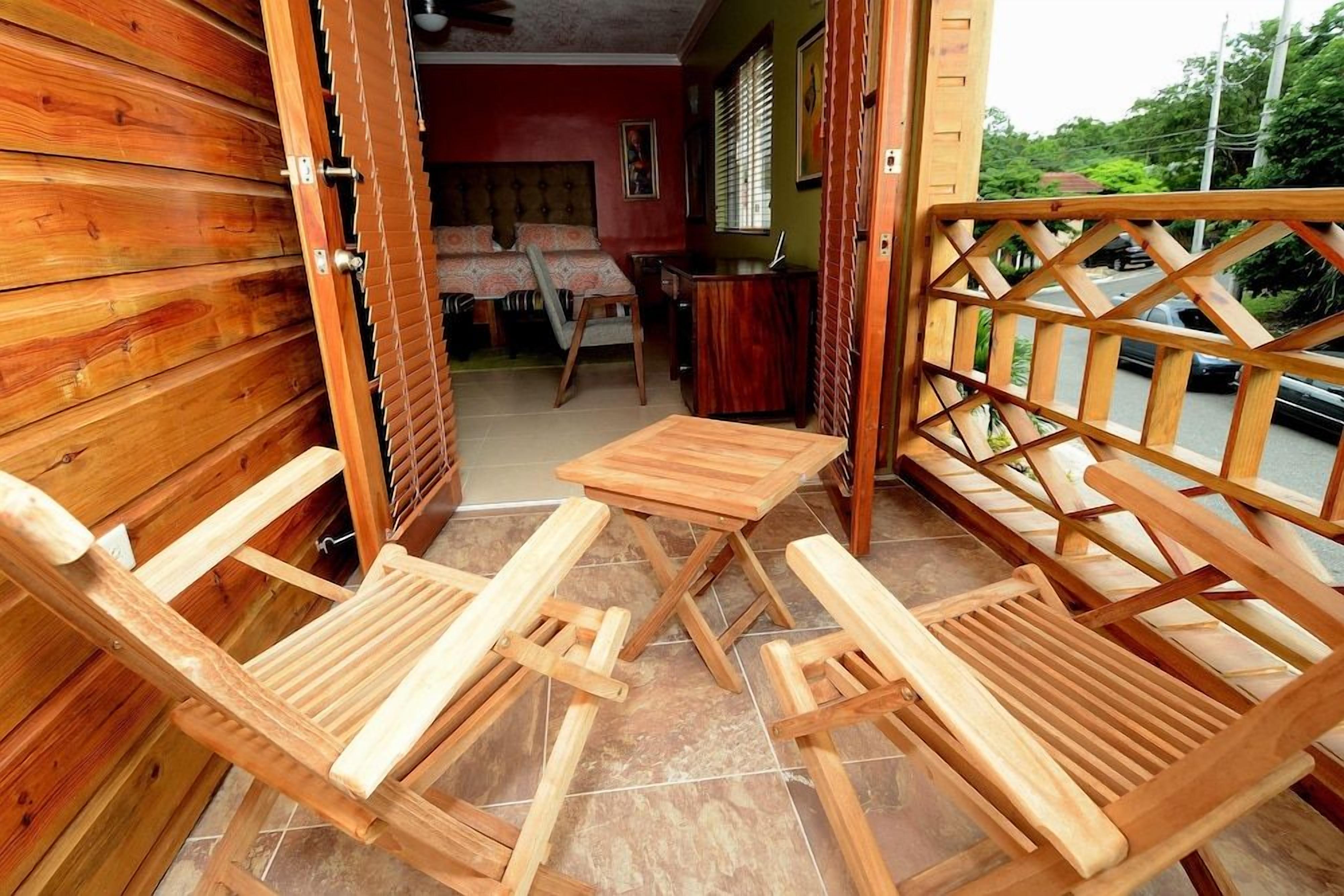 A wooden room with a bed, a table, and two chairs.