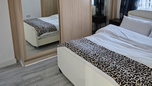 A bedroom with a bed, a wardrobe, a desk, and a mirror. - Spacious 4-Bed House Near Manchester and Trafford Centre, Free Parking & WiFi (Partington)
