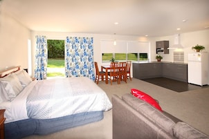 Una habitación de hotel moderna con cama, comedor y kitchenette.
