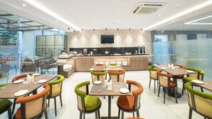 Restaurante moderno com balcão central, divisórias de vidro e diversas opções de assento.